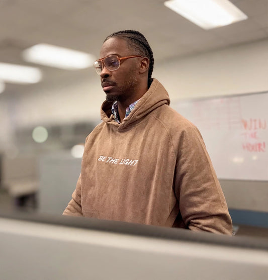 Be the Light Hoodie worn, tan pullover with embroidered Be the Light text